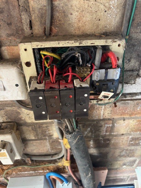 Old wiring found behind a fuse box during a survey